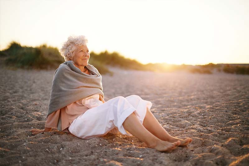 Older Woman Reflecting On The Beach