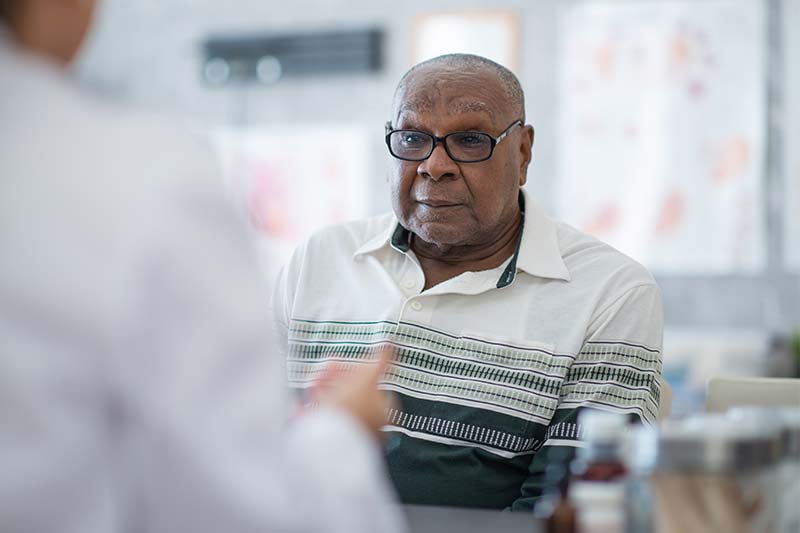 An African American man talks to his doctor in the medical office