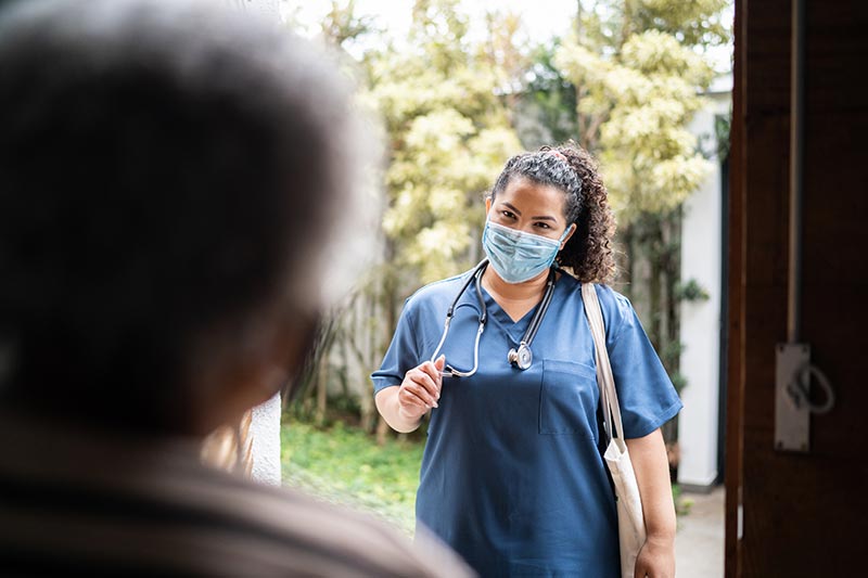 Healthcare worker arriving at patient's house - wearing protective face mask