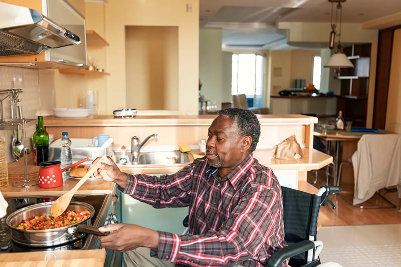 Senior Man Cooking a Dinner with Home Health Care Services