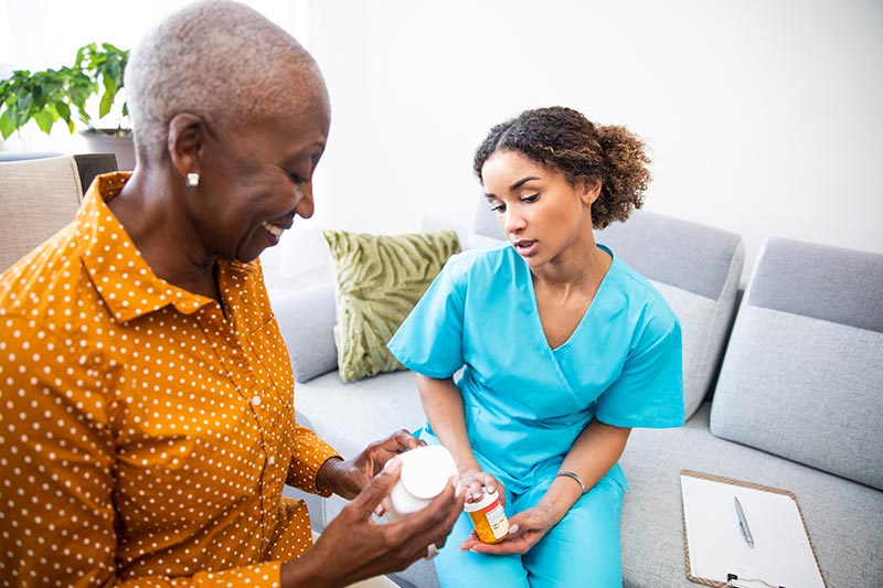 home health aide visiting a patient looking at the medication she is taking
