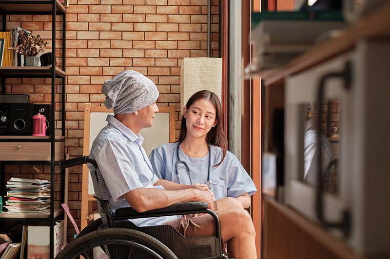 Cancer elderly patients in wheelchairs receive rehabilitation treatment in private home