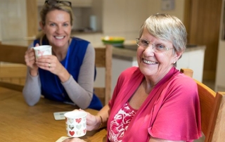 Daughter-joins-mother-for-a-cup-of-tea-while-sitting-at-the-kitchen-table