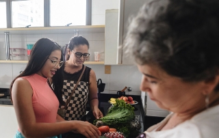 Grandmother and CDPAP caregiver unpacking groceries in the kitchen