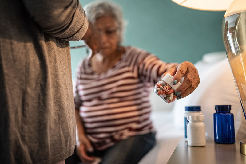Senior woman taking medicines at home