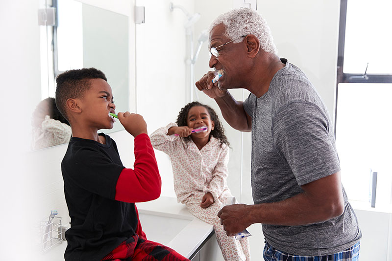 Senior brushing teeth with grandchildren