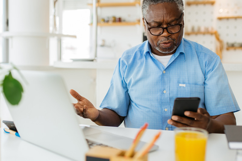 Senior man reading scam email on phone